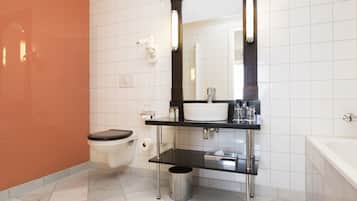 A modern bathroom with a toilet, sink, and bathtub.
