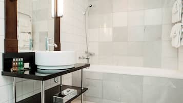A modern bathroom with a white sink, a mirror, and a shower.