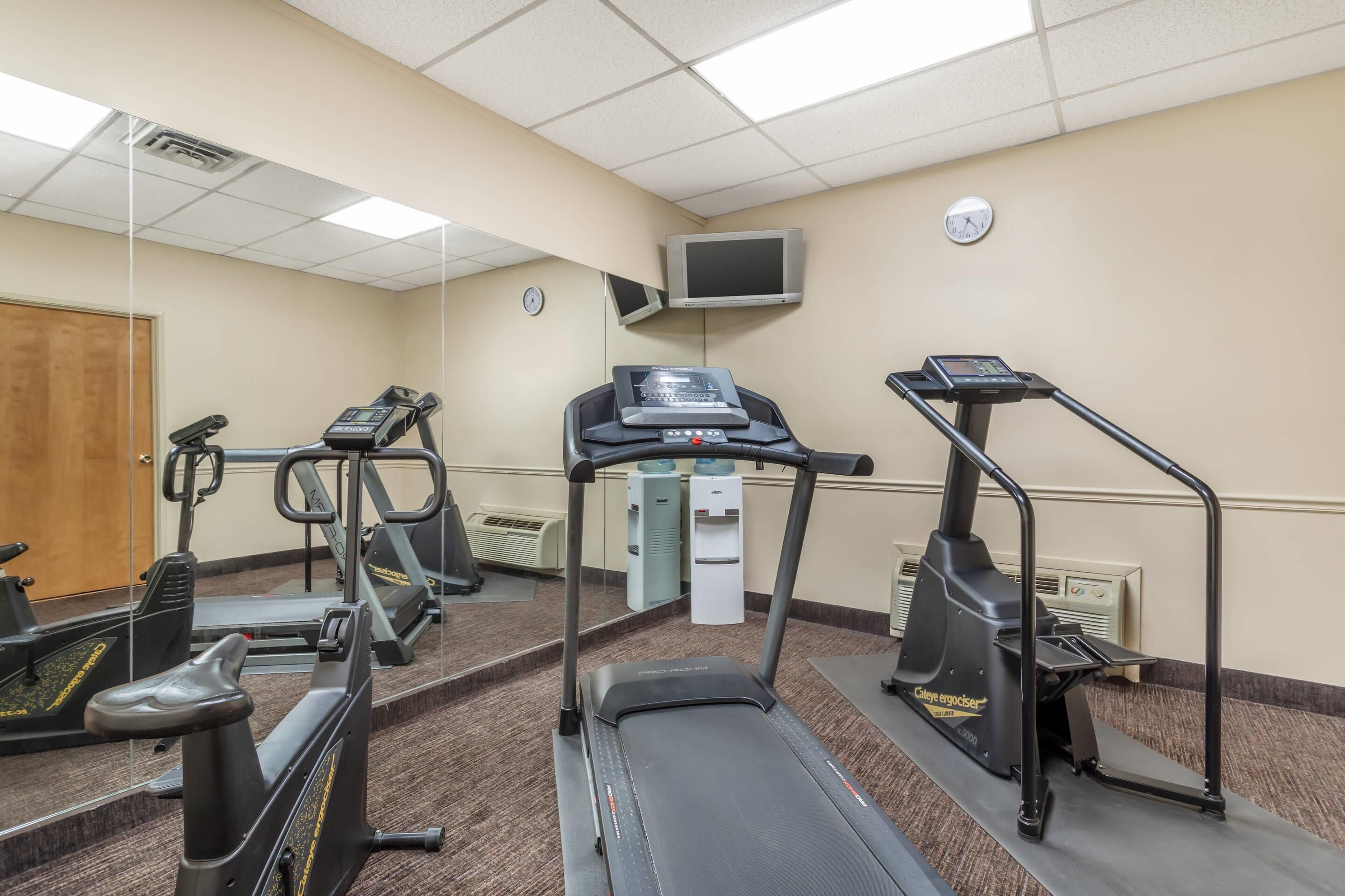 A fitness room with treadmills, an elliptical, and a stationary bike.