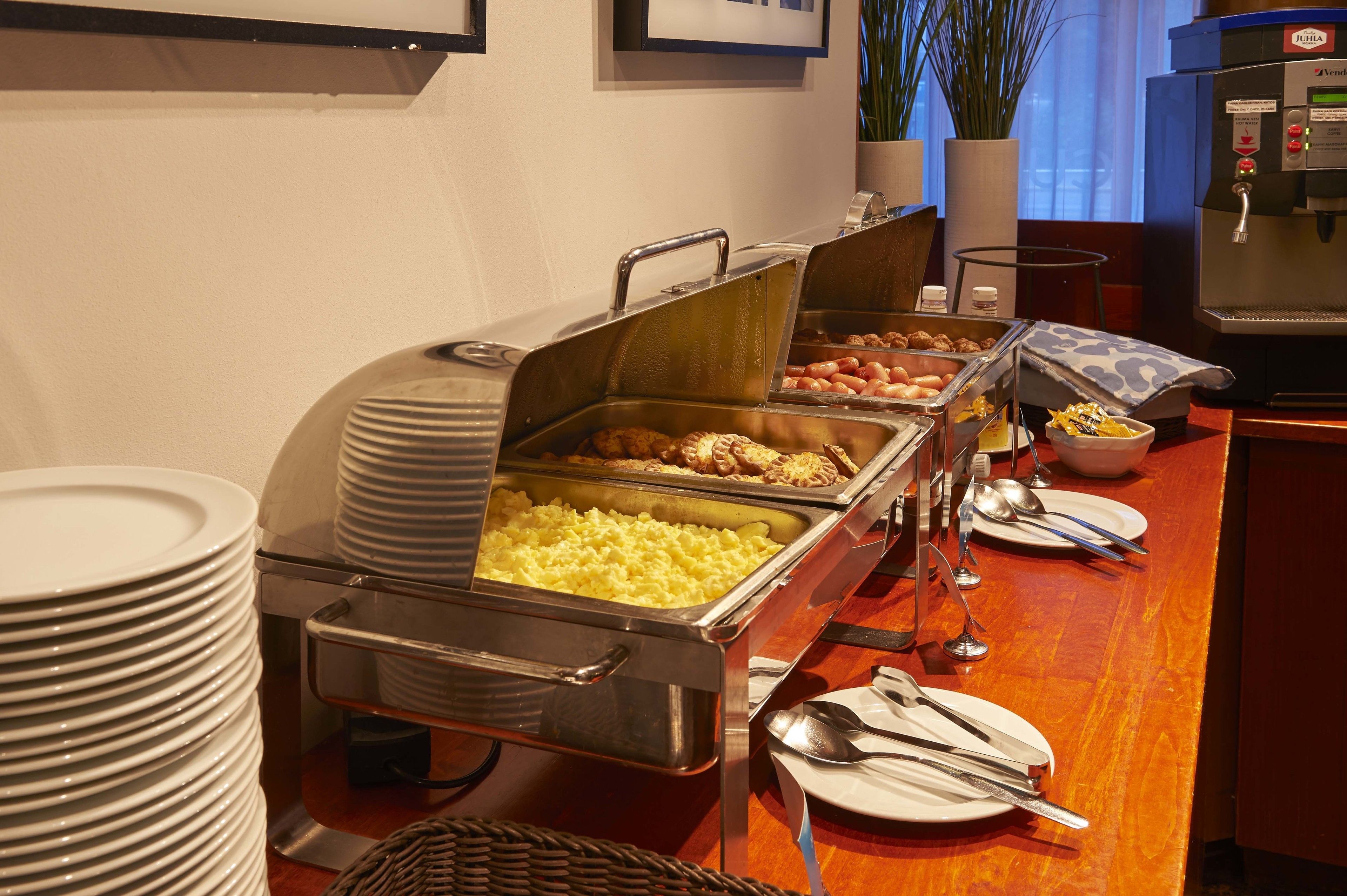A buffet setup with various food items and dining utensils.