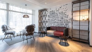 Un salon moderne comprenant un canapé, des fauteuils, une table basse et une bibliothèque.