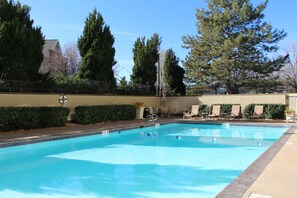 Relax by the inviting pool surrounded by lush greenery and comfortable lounge chairs.