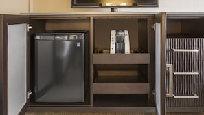 A compact kitchen with a refrigerator, a coffee maker, and a microwave.