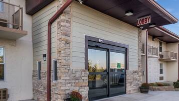 A building with a stone facade, a glass entrance, and a 'Lobby' sign.