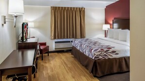 A hotel room with a bed, desk, chair, and a television. - Red Roof Inn Richmond, IN (Richmond)
