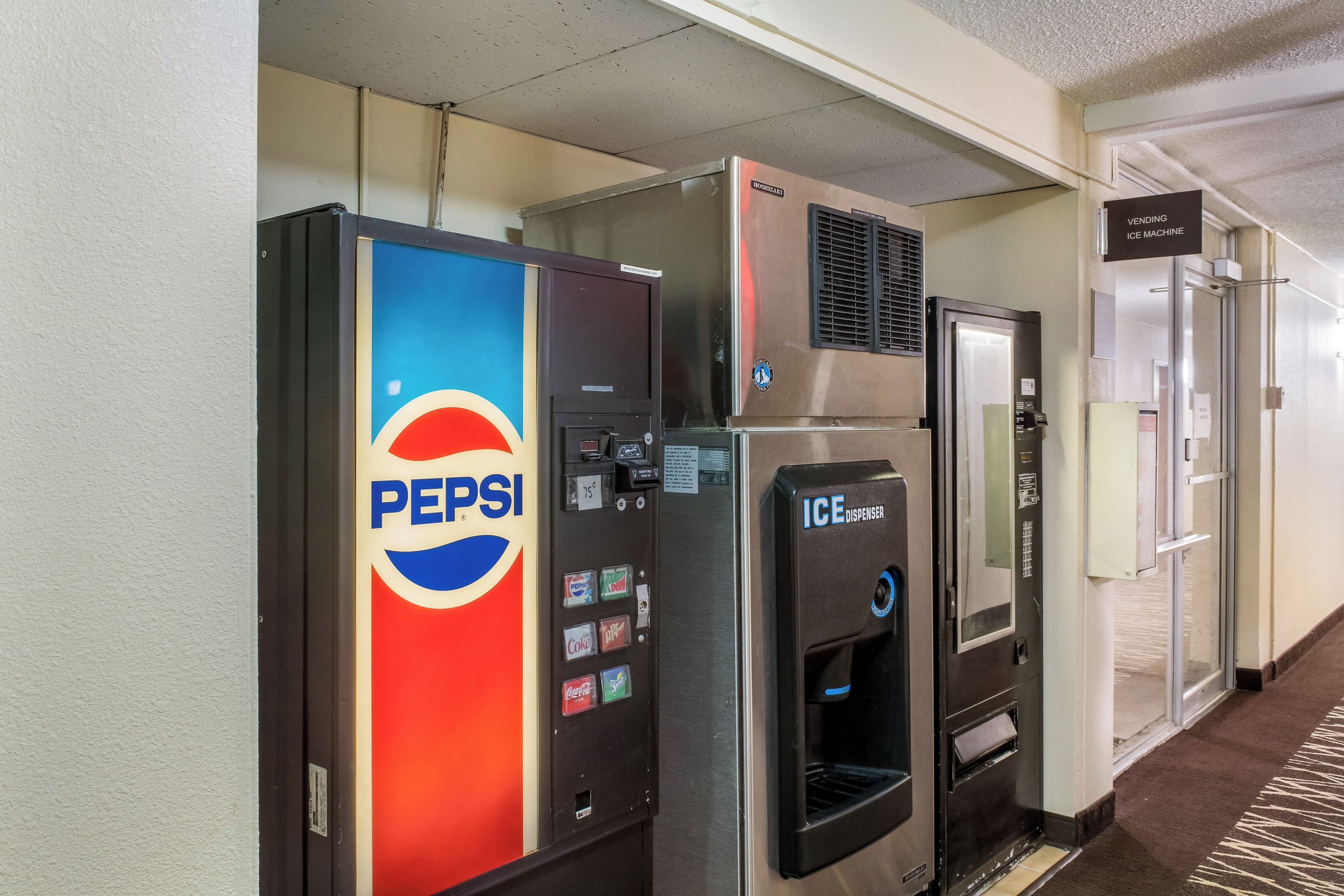 Des distributeurs automatiques de Pepsi et un distributeur de glaçons dans un couloir d’hôtel.