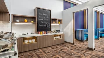 Un rincón para desayunar con una pizarra, una barra de buffet y zona de asientos.
