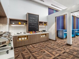 Un rincón para desayunar con una pizarra, una barra de buffet y zona de asientos.