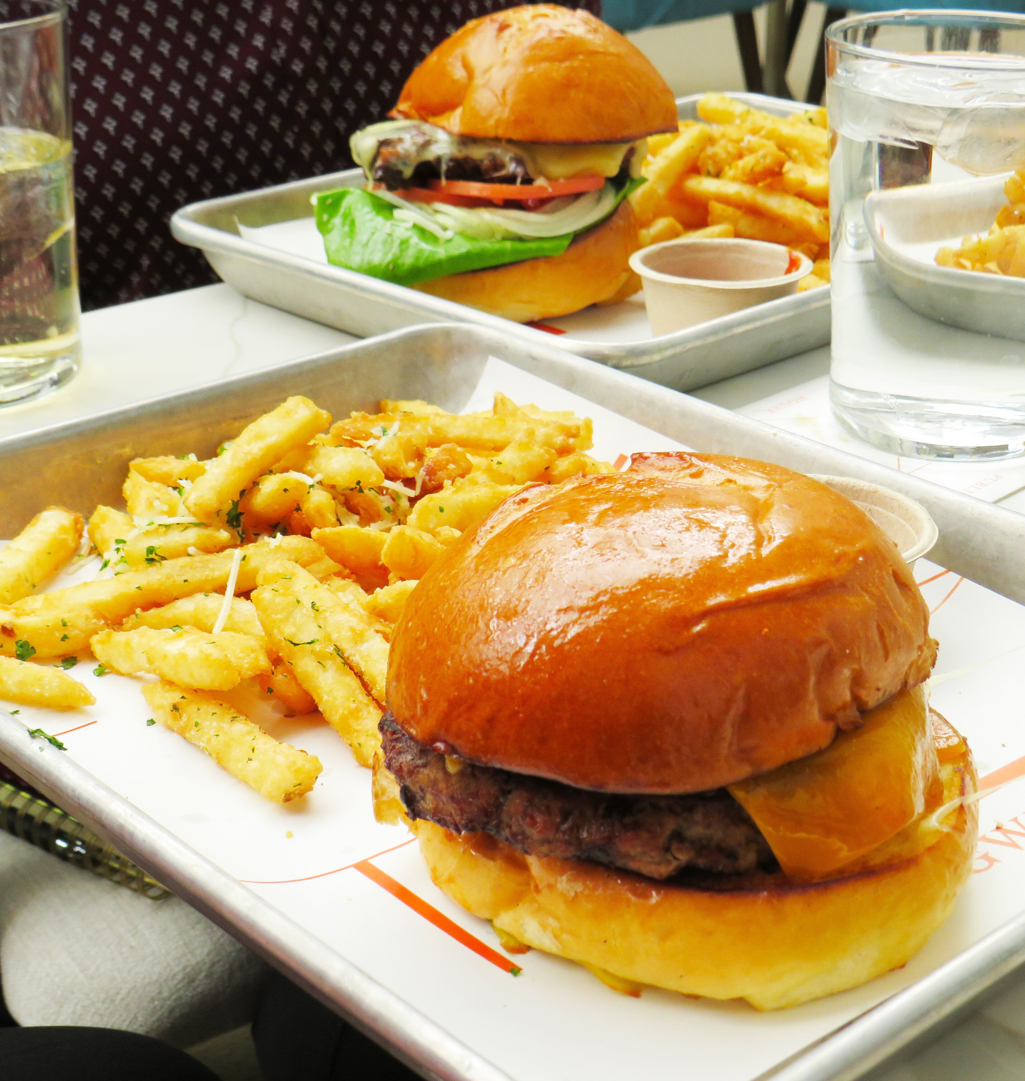 A meal consisting of a burger, fries, and a drink on a tray.