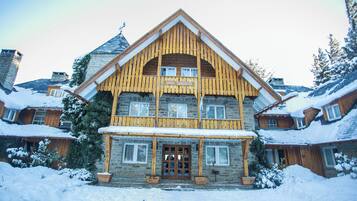 A large wooden hotel with a prominent entrance and multiple windows.