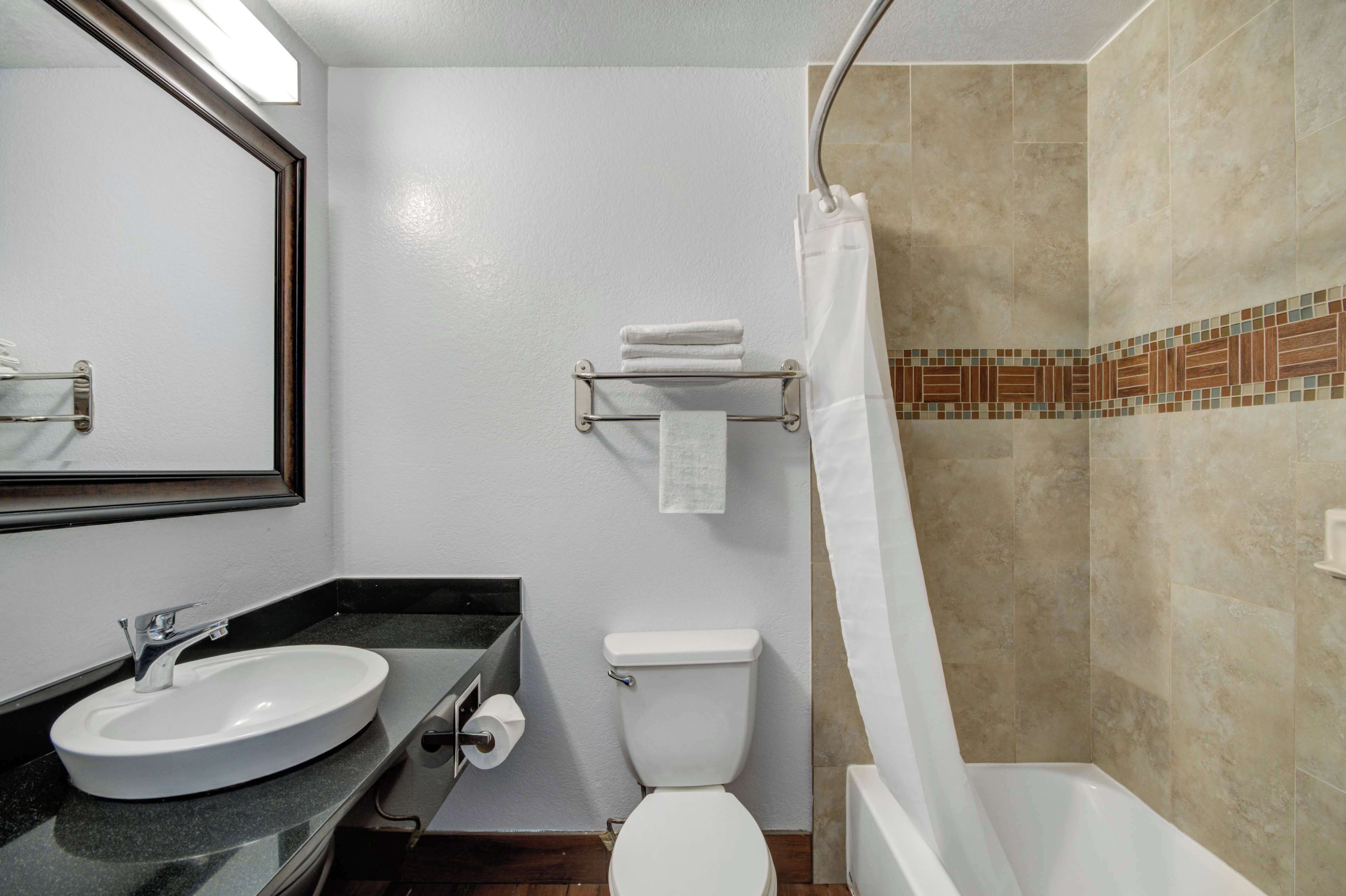 Un baño con lavamanos, inodoro y ducha.