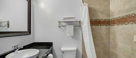 Un baño con lavamanos, inodoro y ducha.