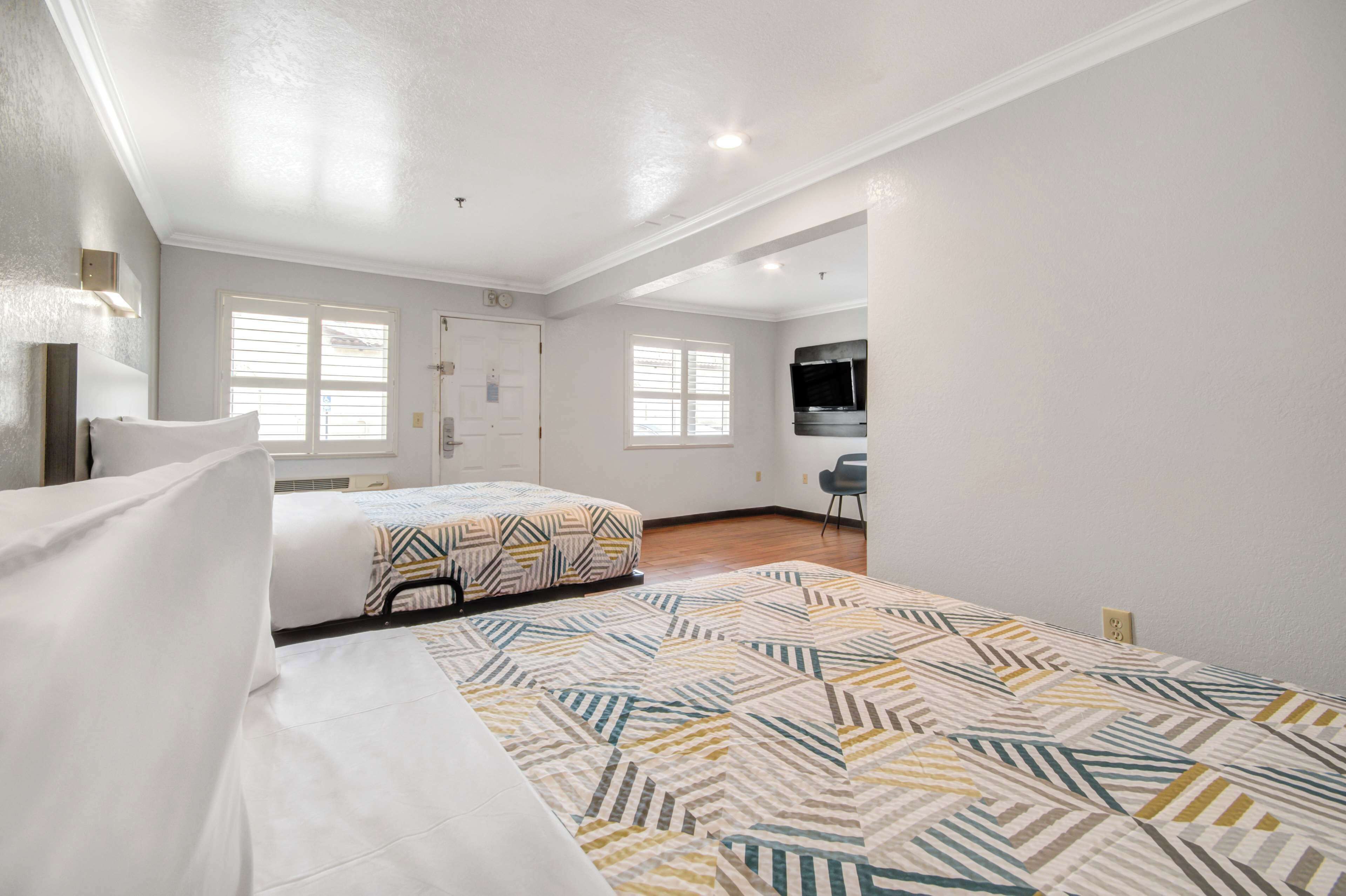 Un dormitorio con cama, escritorio y silla.
