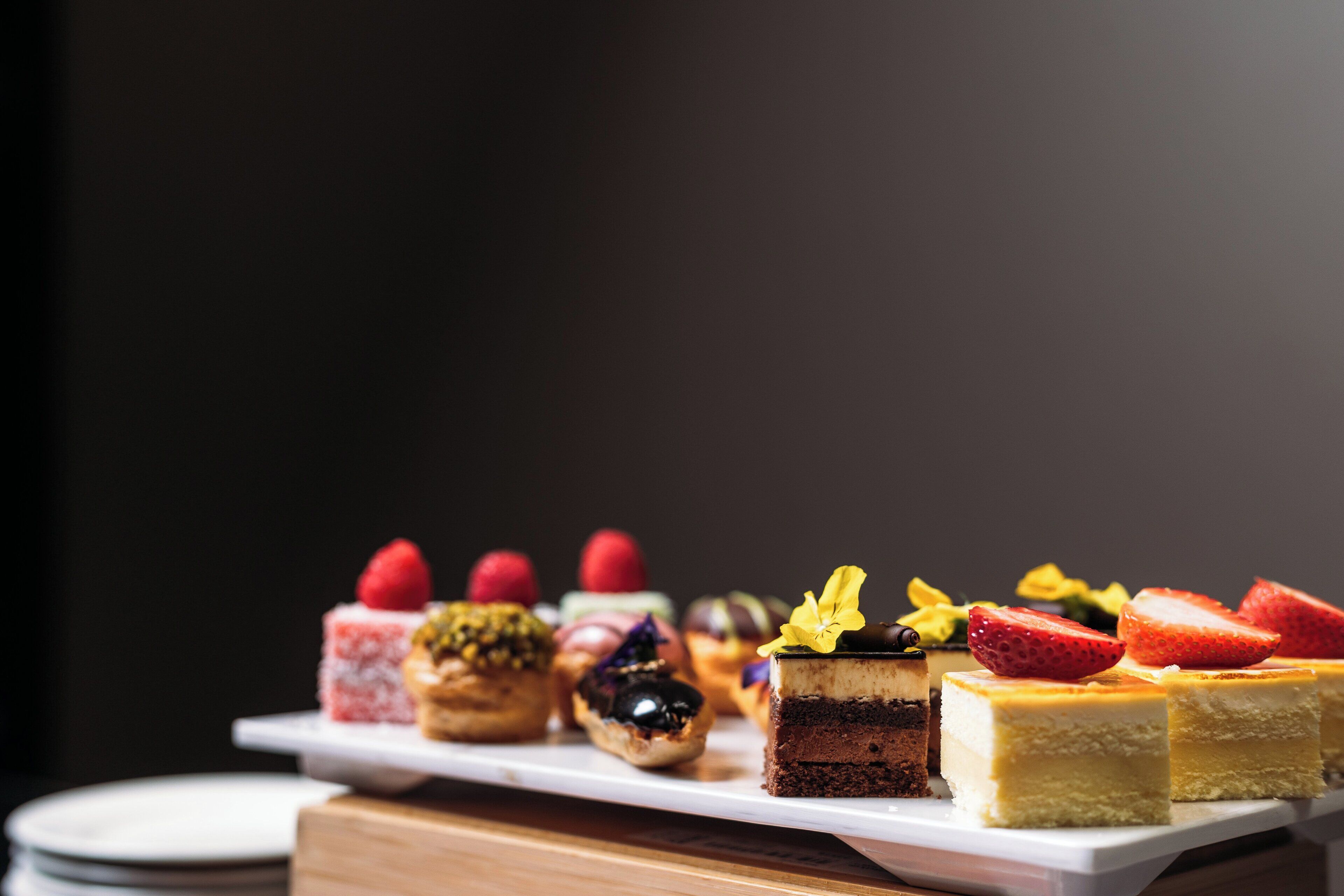 A variety of desserts on a white rectangular plate.