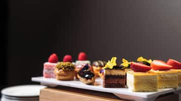A variety of desserts on a white rectangular plate.