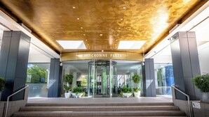 A modern entrance with a glass door, a sign reading "CROWNE PLAZA," and a staircase leading up. - Crowne Plaza Canberra by IHG (Canberra)