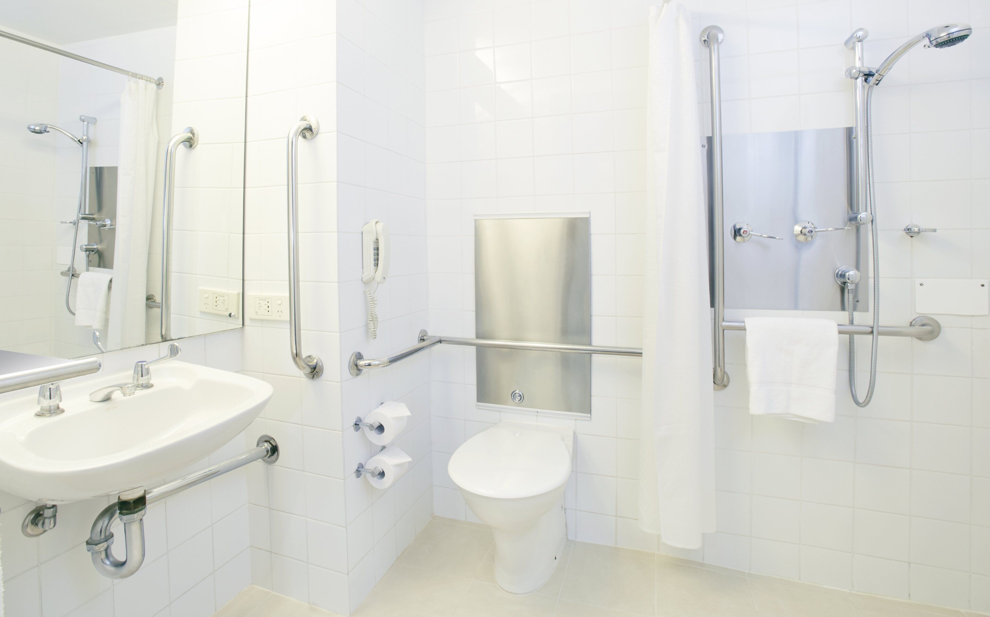 A modern bathroom with a sink, toilet, and shower.