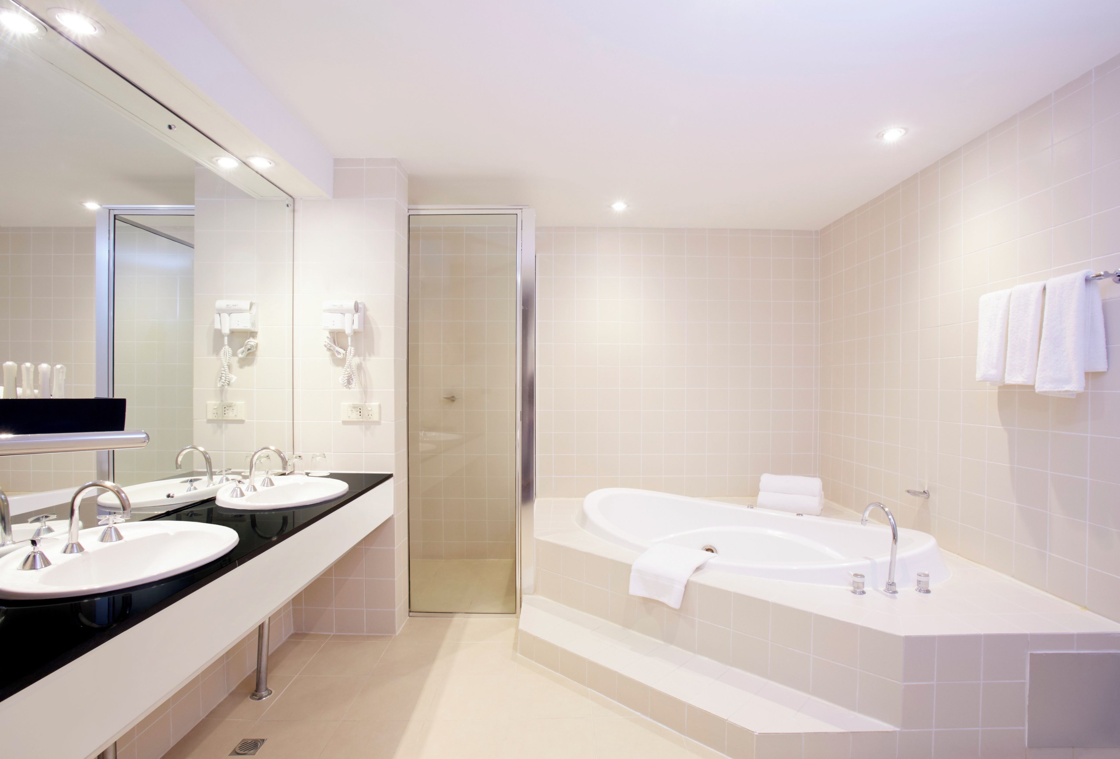 A modern bathroom with a double sink vanity, a walk-in shower, and a freestanding bathtub.