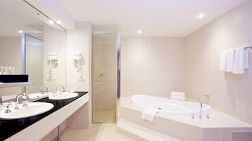 A modern bathroom with a double sink vanity, a walk-in shower, and a freestanding bathtub.