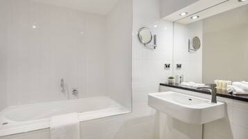 A modern bathroom with a bathtub, a sink, and a mirror.