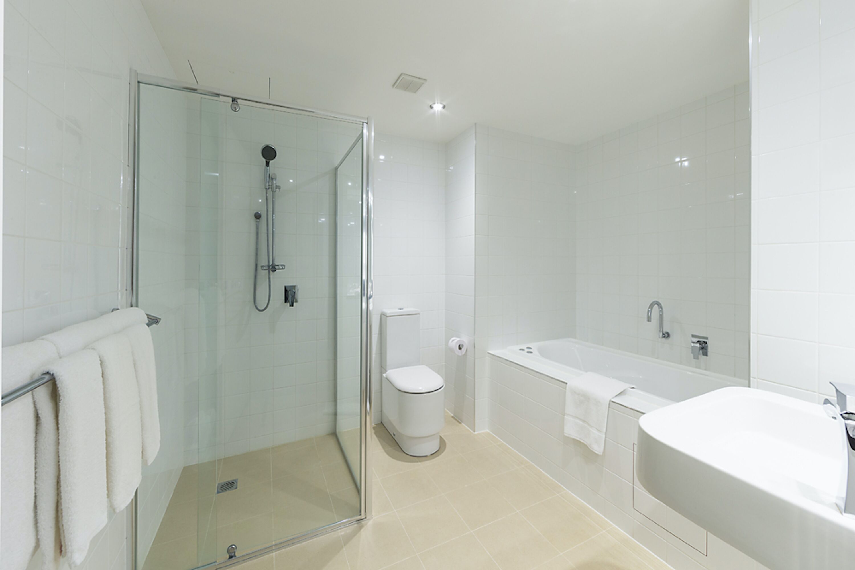 Un baño moderno con ducha de vidrio, inodoro y una bañera grande.