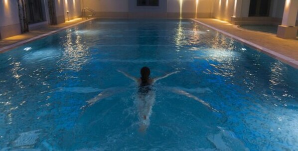 Una piscina amb una persona nedant al centre.