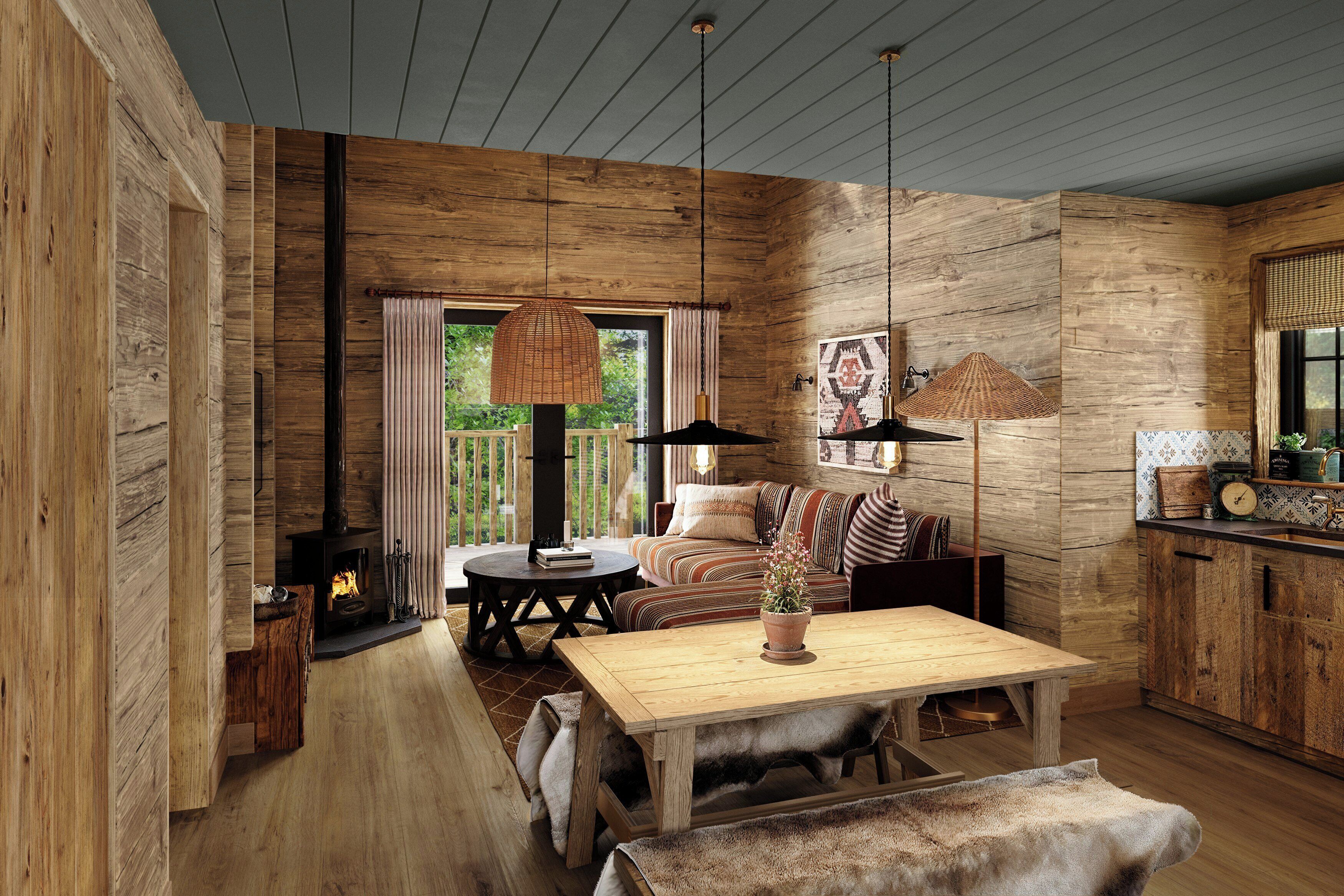 A rustic interior with a wooden floor, a sofa, a table, and a fireplace.