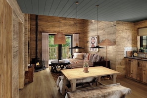 A rustic interior with a wooden floor, a sofa, a table, and a fireplace.