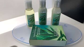 A bathroom counter with a box of 'rainkissed leaves' products and three bottles of lotion.