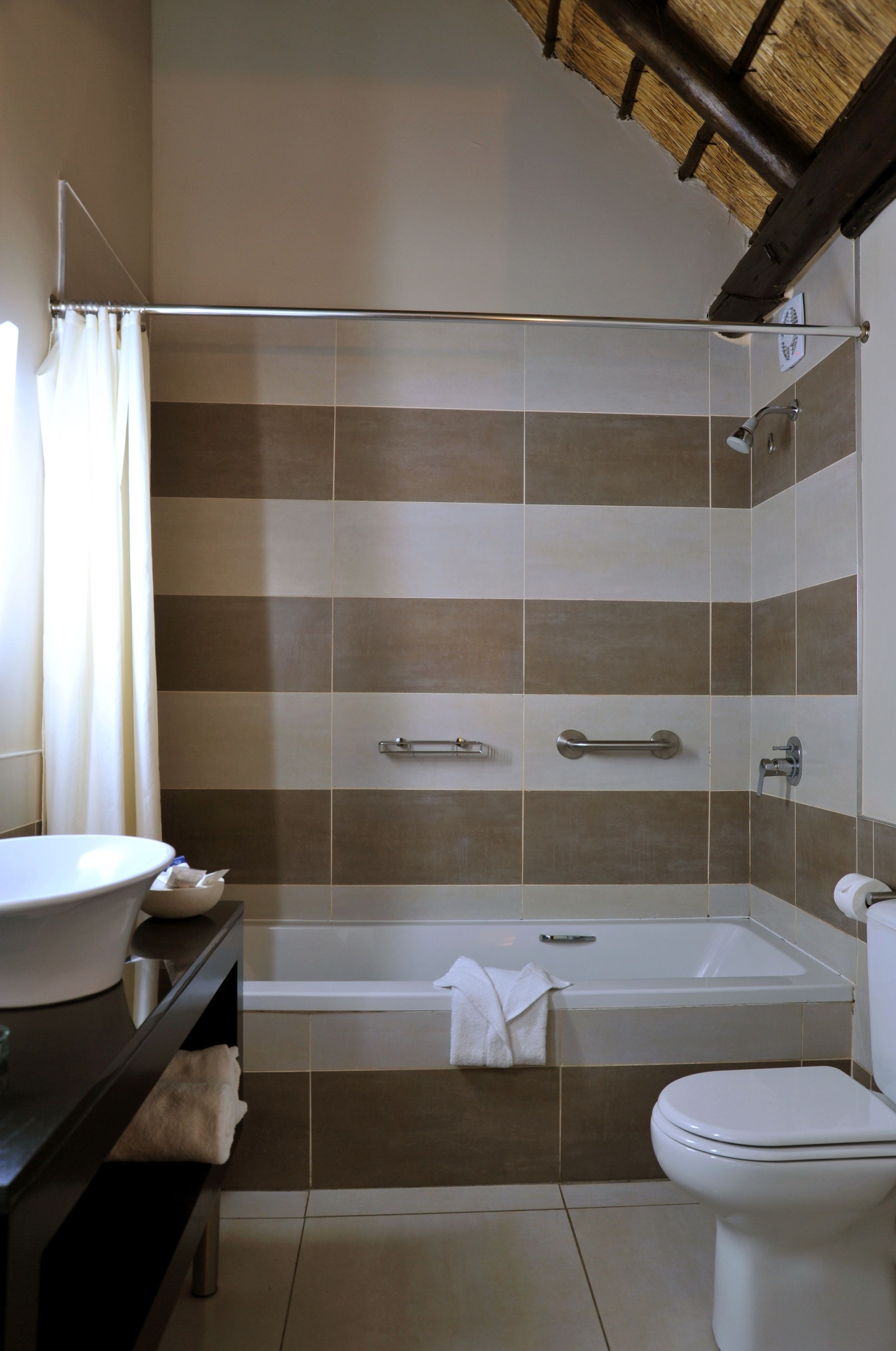 A bathroom with a bathtub, toilet, and sink.