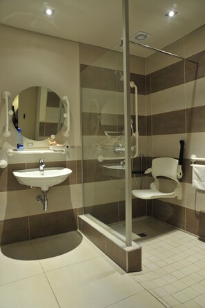 A modern bathroom with a sink, mirror, and shower.