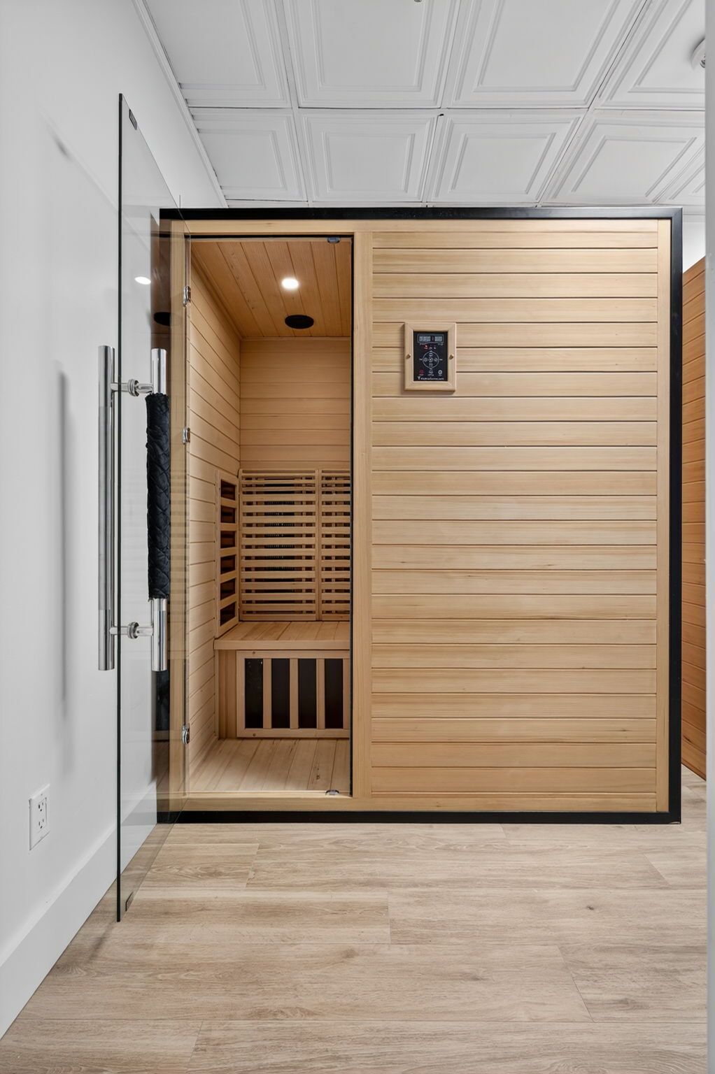 Et sauna rum med trævægge og et kontrolpanel.