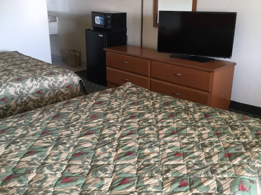 Een hotelkamer met een bed, een kaptafel, een televisie en een magnetron.