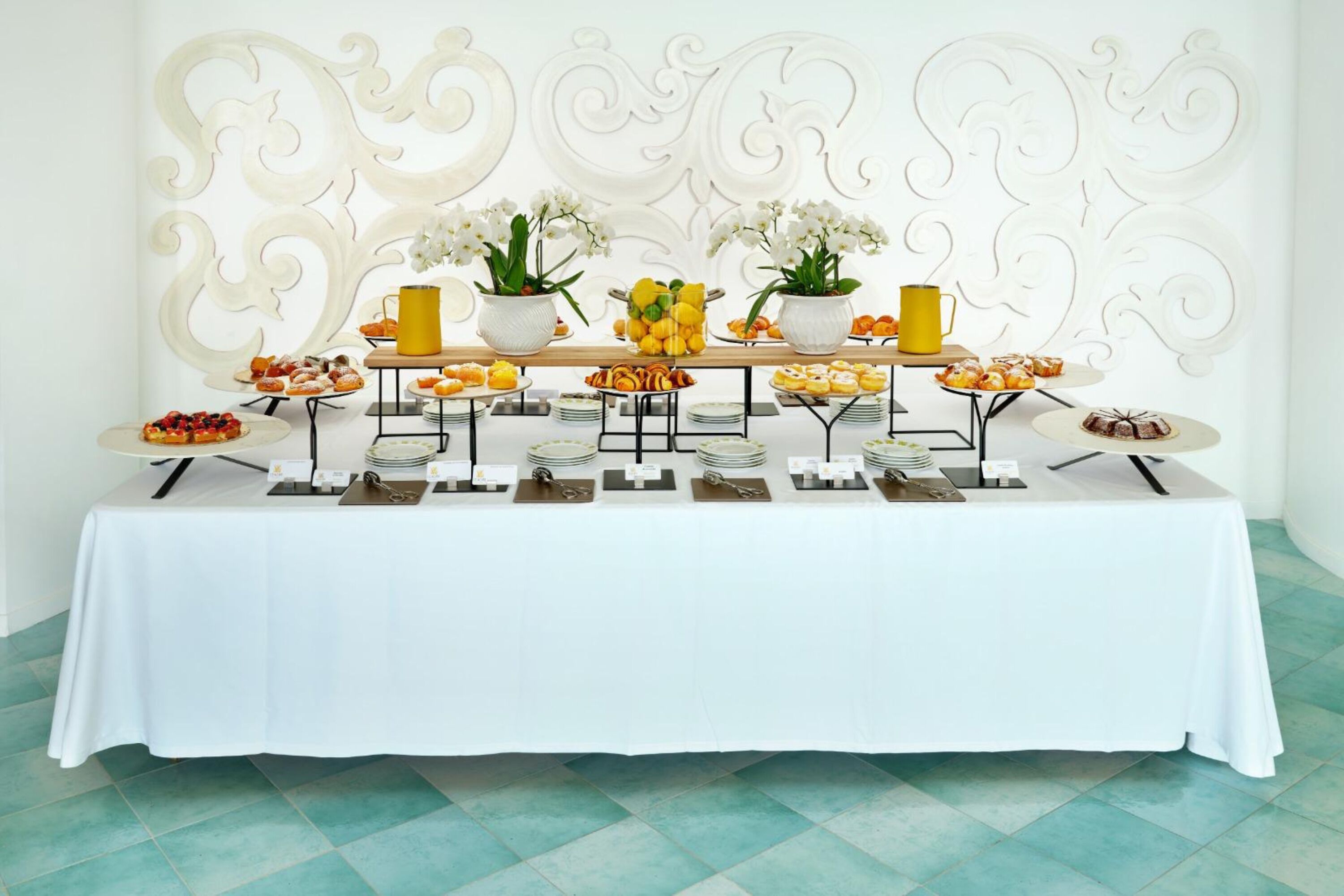 A buffet table with various food items and a decorative wall in the background.