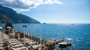 Aan een privéstrand, ligstoelen, parasols, strandlakens