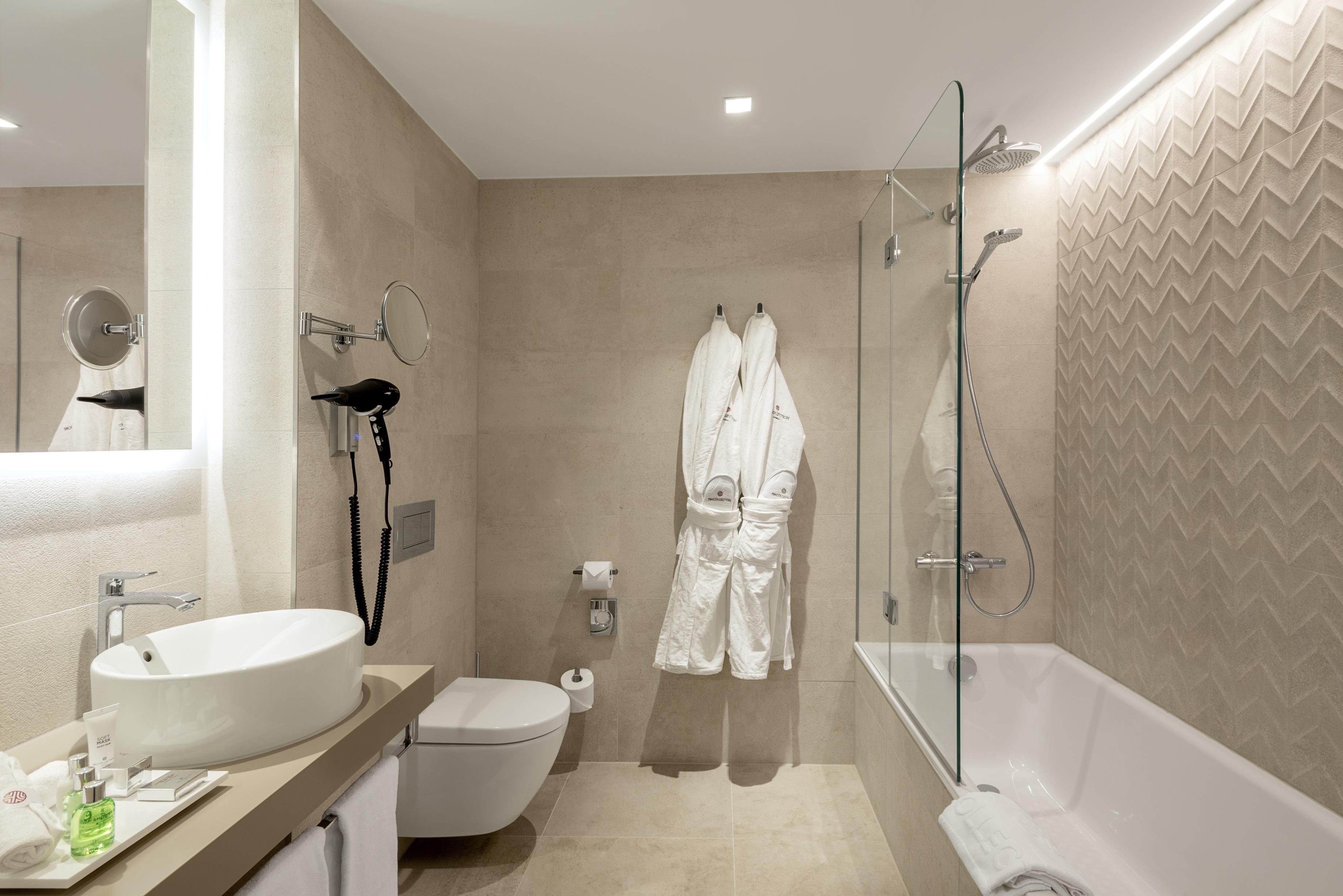 A modern bathroom with a bathtub, toilet, and sink.