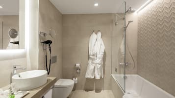 A modern bathroom with a bathtub, toilet, and sink.