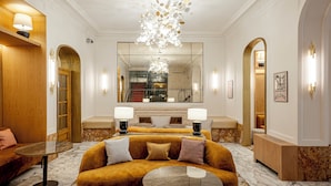 A luxurious lobby with a plush sofa, a marble coffee table, and a modern chandelier.