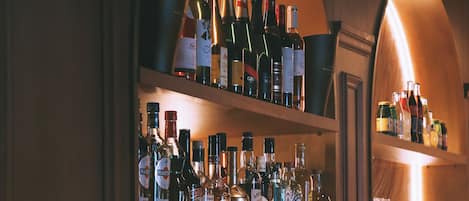 Un espace bar avec des étagères remplies de différentes bouteilles d’alcool et un appareil à café.
