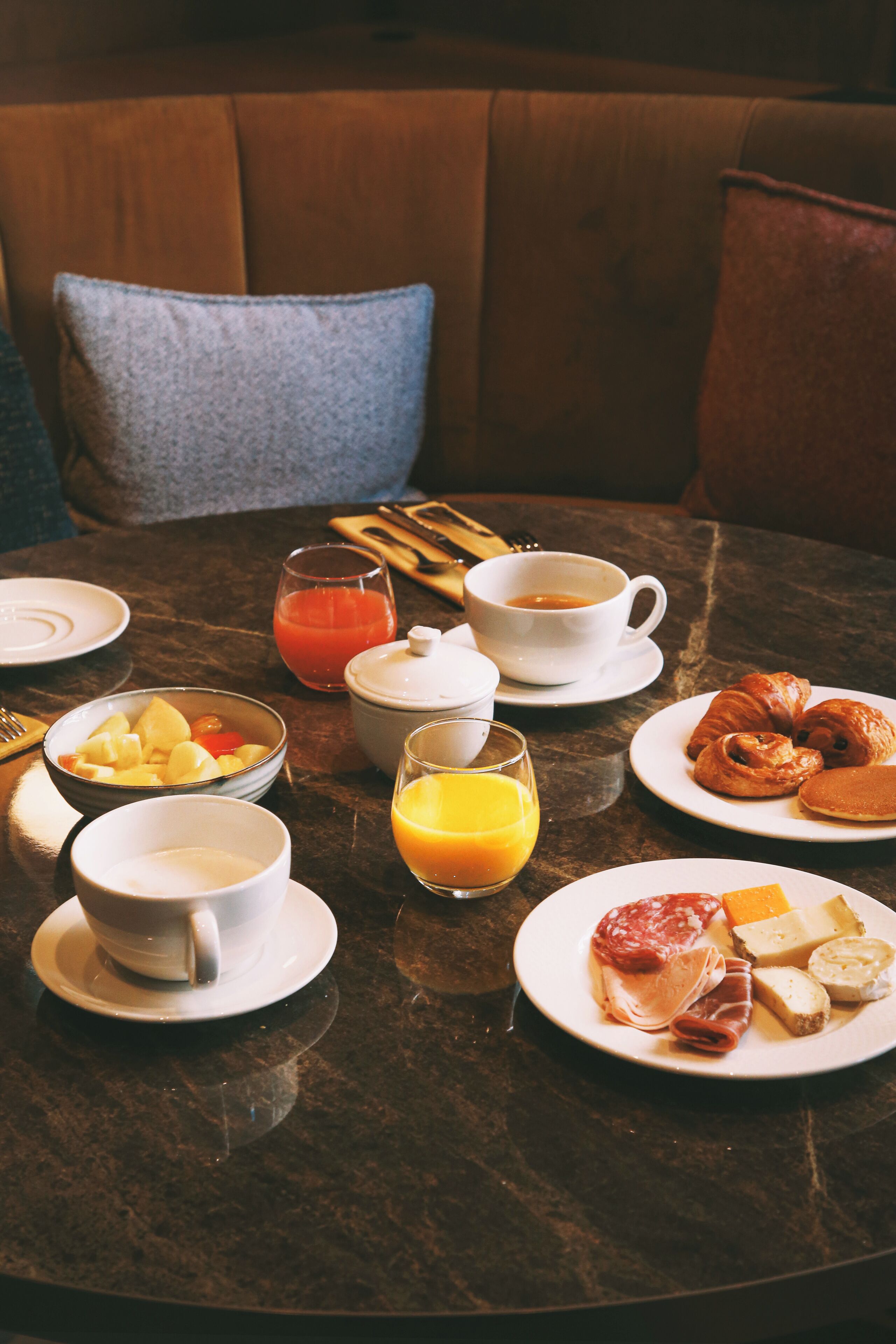 Een ontbijttafel met diverse gerechten, zoals croissants, kaas en fruit.