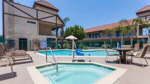 A pool area with lounge chairs, a table with chairs, and a sign indicating a 3 ft depth. - Howard Johnson by Wyndham Norco (Norco)
