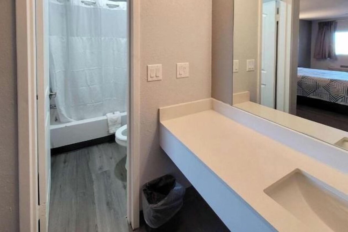 A bathroom with a bathtub, a toilet, and a sink with a mirror.