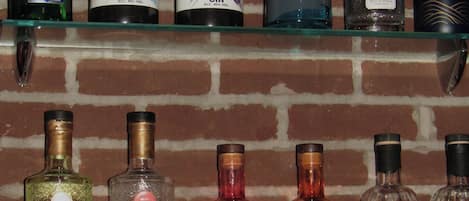 A selection of gin bottles on a glass shelf against a brick wall.
