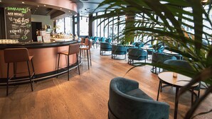 Un espace bar avec un comptoir, des tabourets et un tableau affichant le menu.