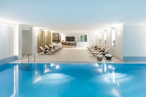 Un espace piscine avec des chaises longues et un comptoir d’accueil.