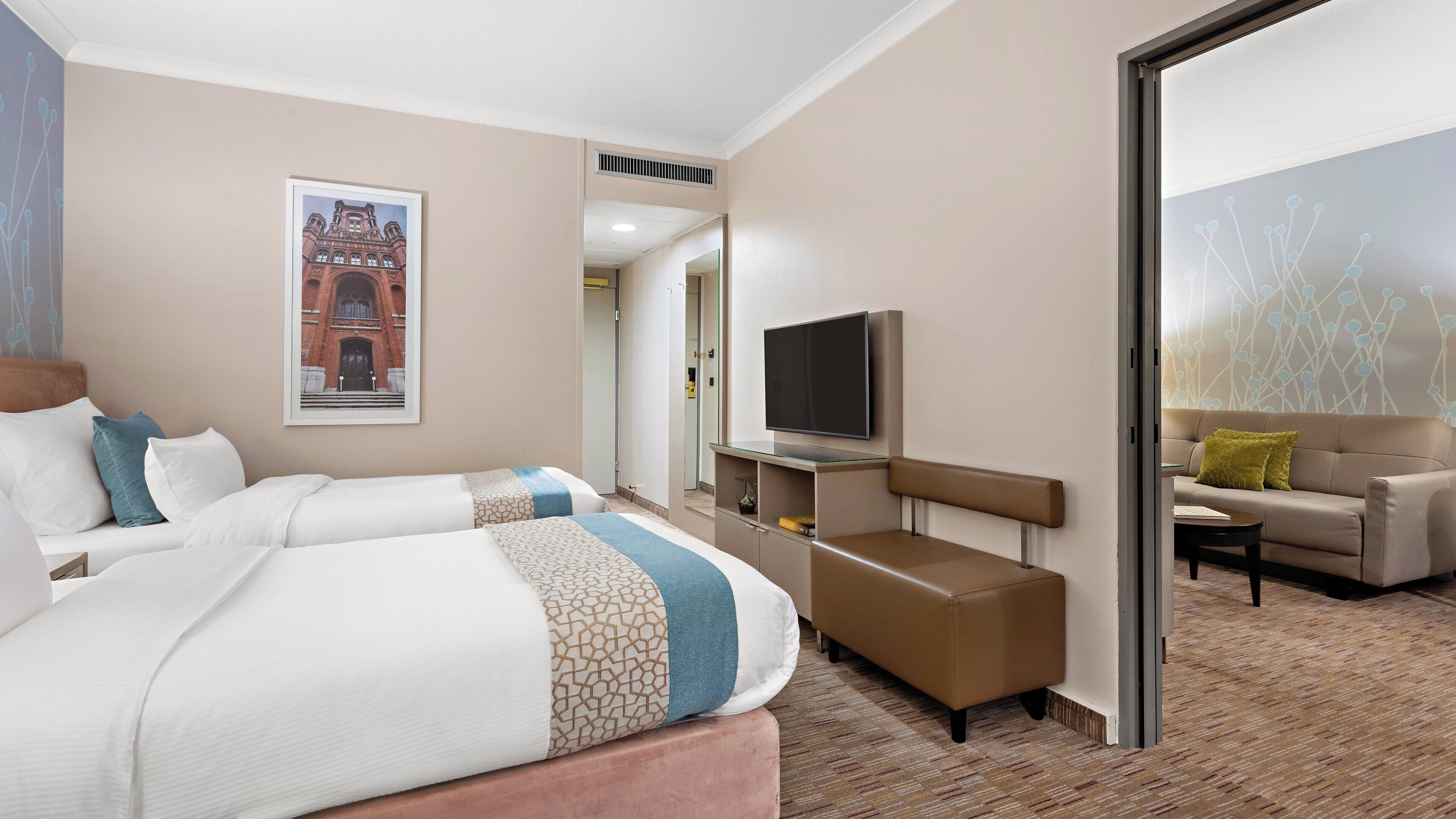 Ein Hotelzimmer mit einem großen Bett, einem Fernseher, einer Couch und einem Couchtisch.