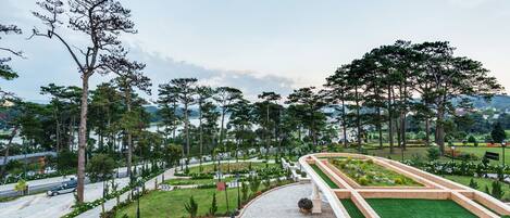 A landscaped garden with pathways, trees, and a central lawn area.