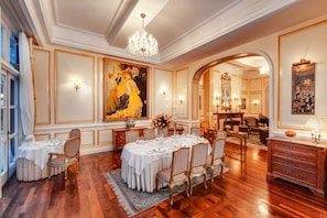 Un comedor formal con una mesa grande dispuesta para seis personas, rodeada de sillas tapizadas.
