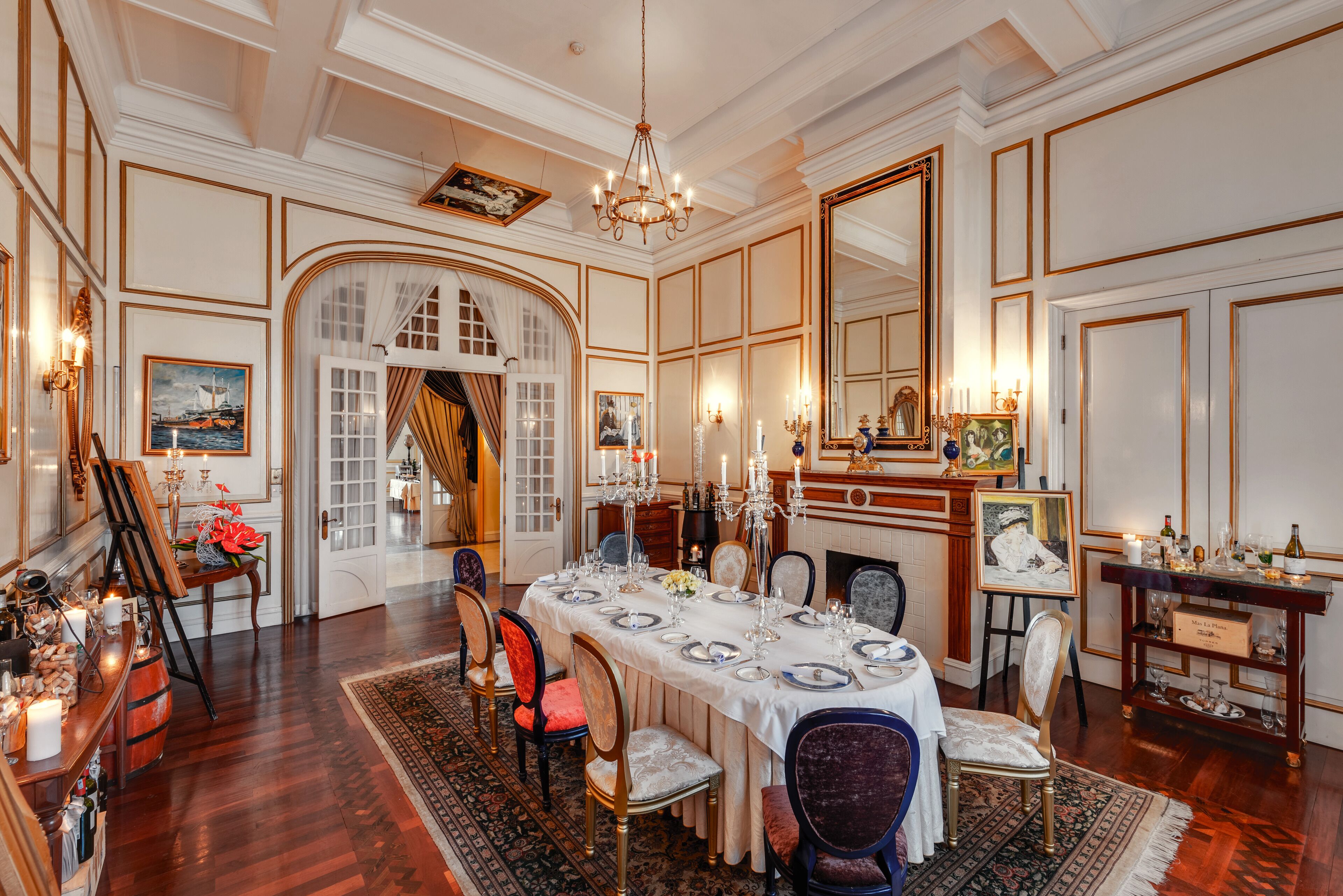 Een stijlvolle eetzaal met een lange tafel gedekt voor een maaltijd, omringd door stoelen.
