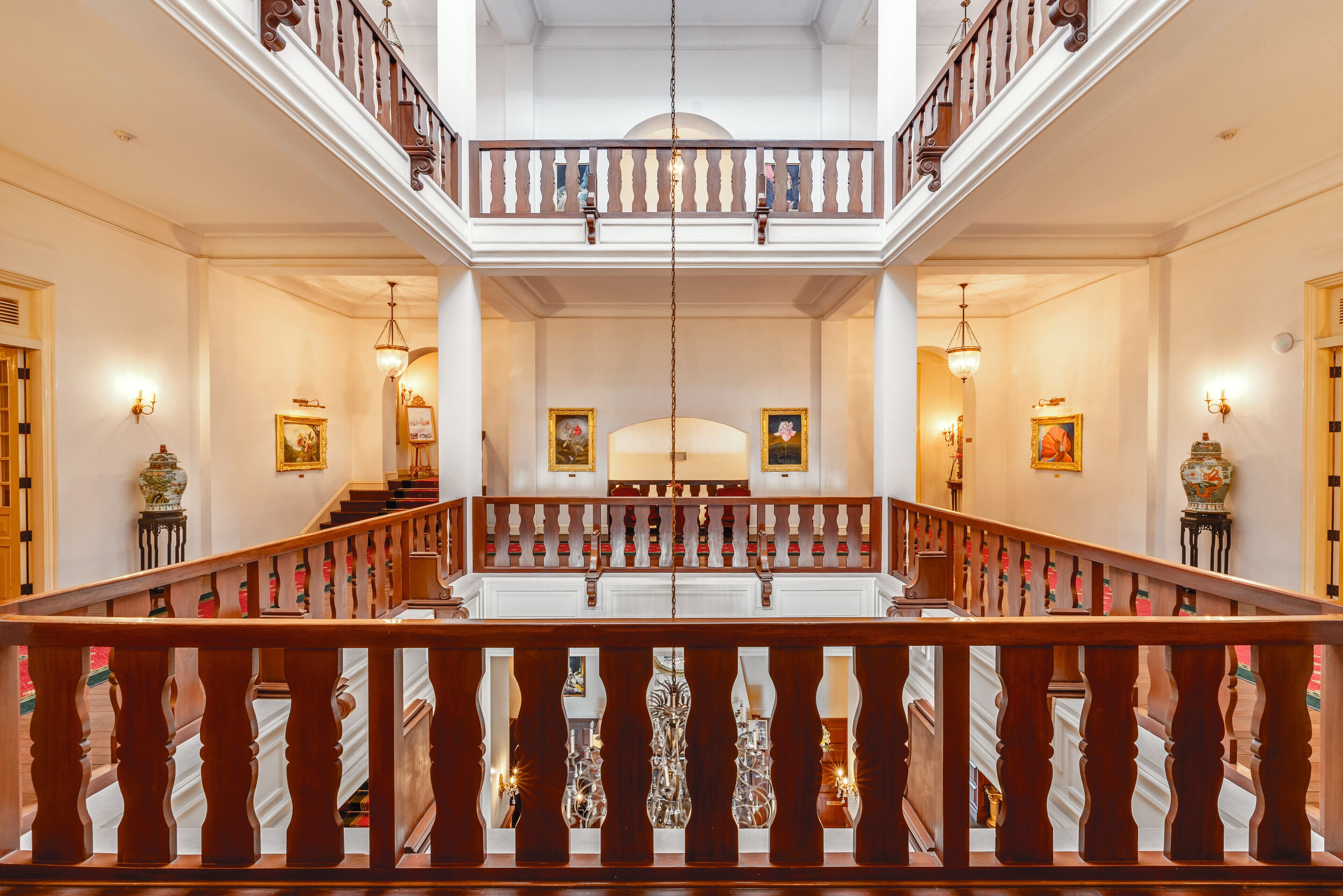 Un magnifique escalier orné d’une balustrade, menant à un balcon d’où l’on peut admirer l’intérieur.